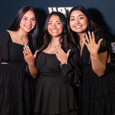 Three senior students show off their rings at ETBU's ring blessing ceremony